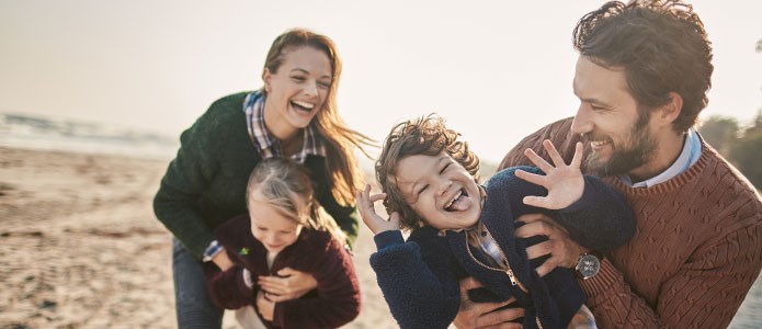 Småbørnsfamilie laver sjov på strand i Danmark