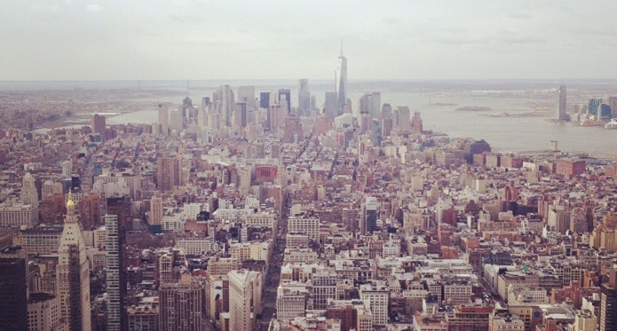 Panoramisk udsigt over New York med høje bygninger og skyskrabere, der strækker sig mod horisonten.