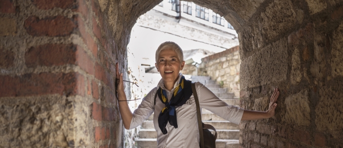 Moden kvinde udforsker en gammel bygning i Beograd