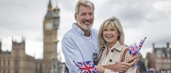 Modent par med flag på Westminster Bridge foran Big Ben i London