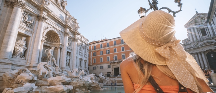 Turist med solhat foran Fontana di Trevi i Rom