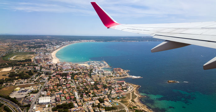 Direkte fly til Mallorca - udsigt over turkisblåt hav fra flyet
